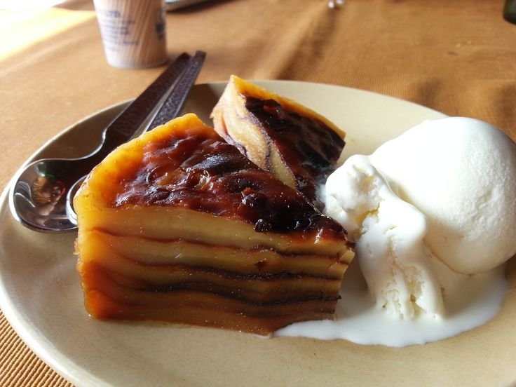 A slice of Bebinca with a side of whipped cream