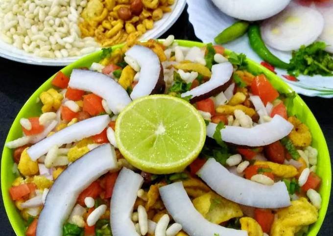 A bowl of Jhal Mudi with fresh coriander and lemon wedges