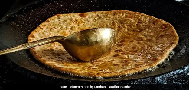 Parathas being cooked in a pan.